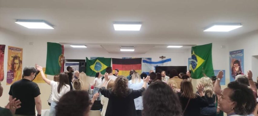 Menschen feiern mit Flaggen von Brasilien und Deutschland in einem festlichen Raum.